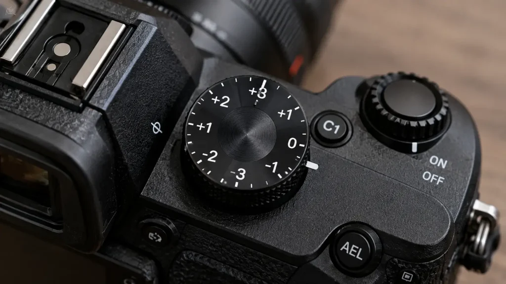 Close up of what is exposure compensation in photography camera dial with plus and minus numbers.